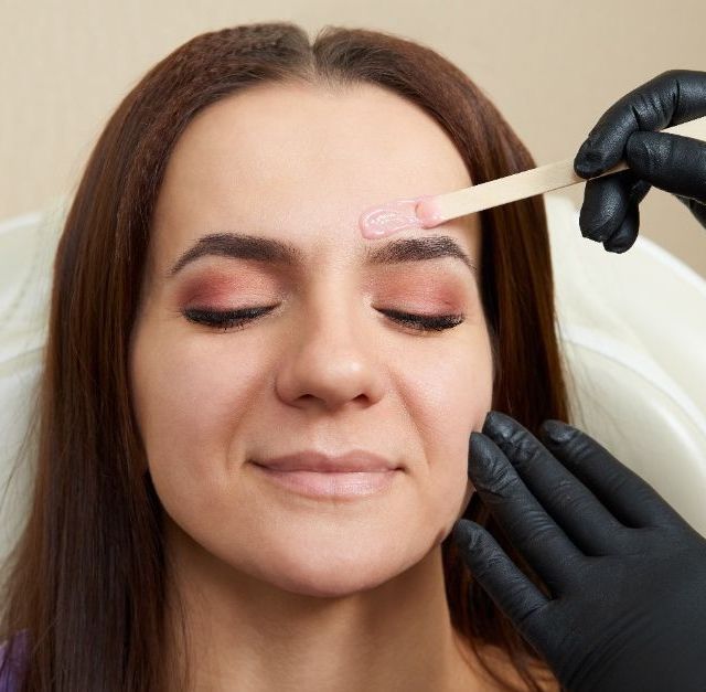 DEPILACIÓN DE CEJAS A UNA MUJER